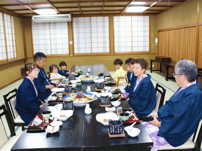 Emi Linds at a traditional Japanese family dinner, seated in a tatami room with relatives in yukata robes
